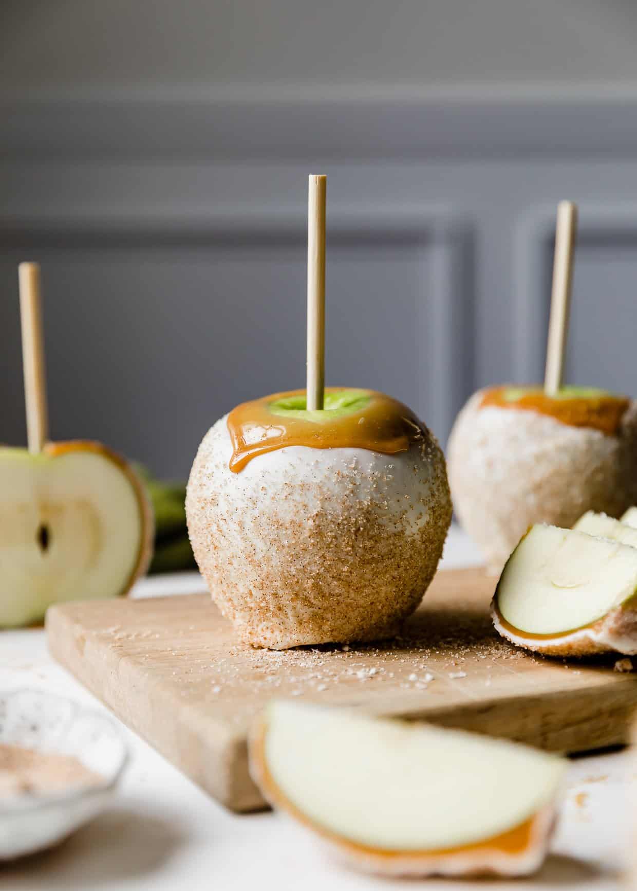 An apple pie caramel apple dipped in caramel, coated with white chocolate and sprinkled with cinnamon sugar.