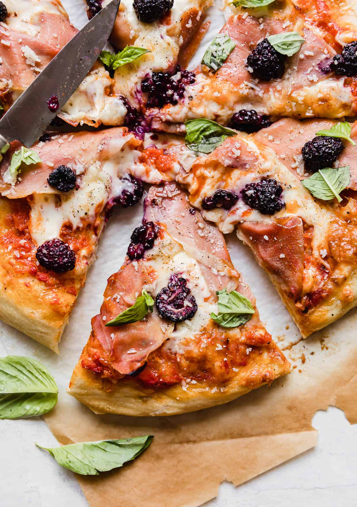 A slice of Blackberry Pizza on a brown parchment paper.