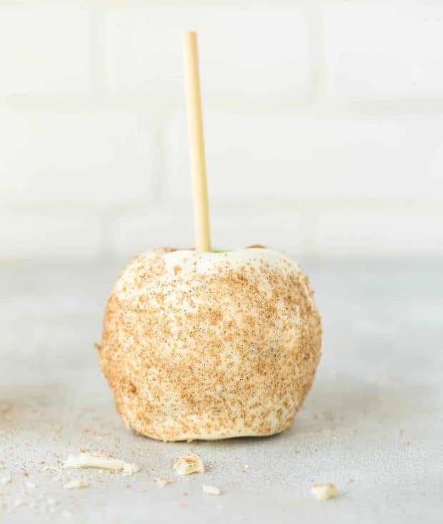 An apple coated in caramel, white chocolate, and cinnamon sugar.