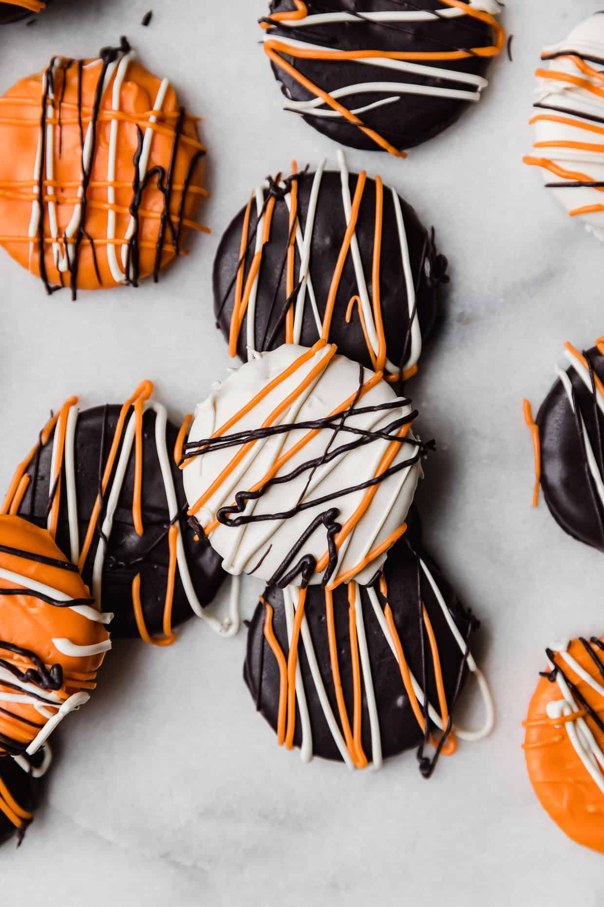 Ritz crackers covered in black, orange, and white chocolate.