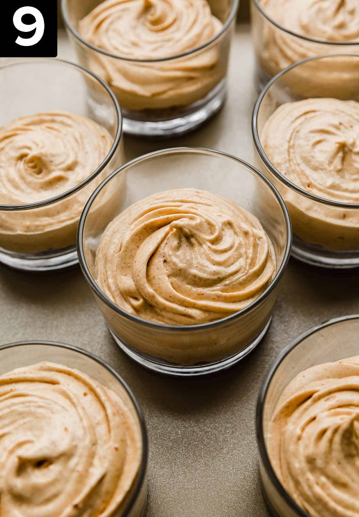 Glass cups filled with graham cracker crust and a no-bake pumpkin cheesecake filling with cool whip.