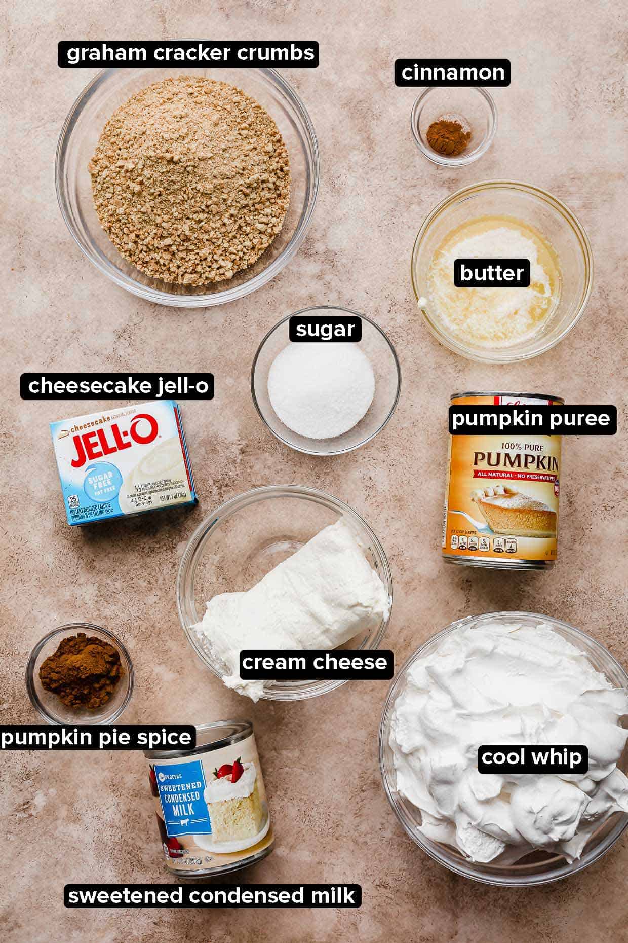 No-bake pumpkin cheesecake ingredients on a brown background.