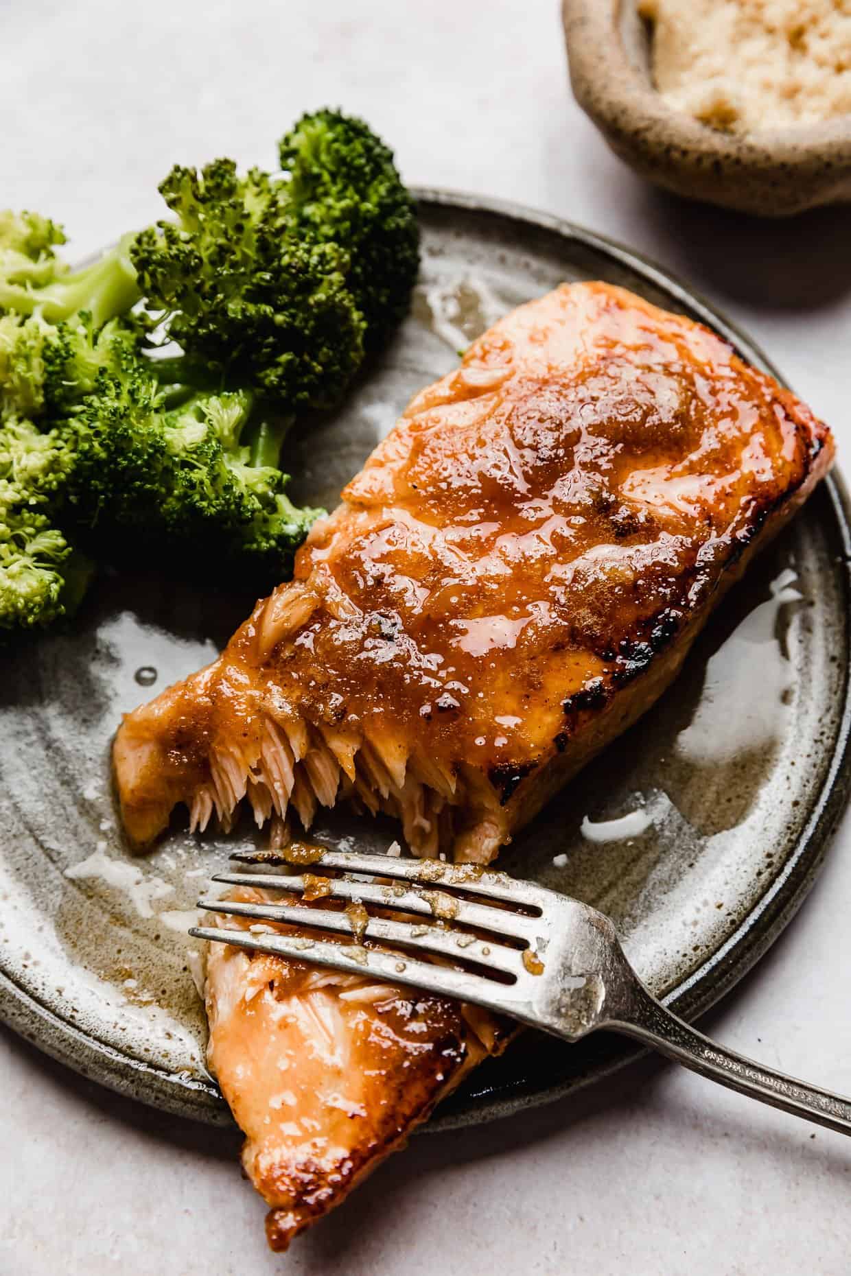 Brown Sugar glazed Salmon on a grey plate on a white background.