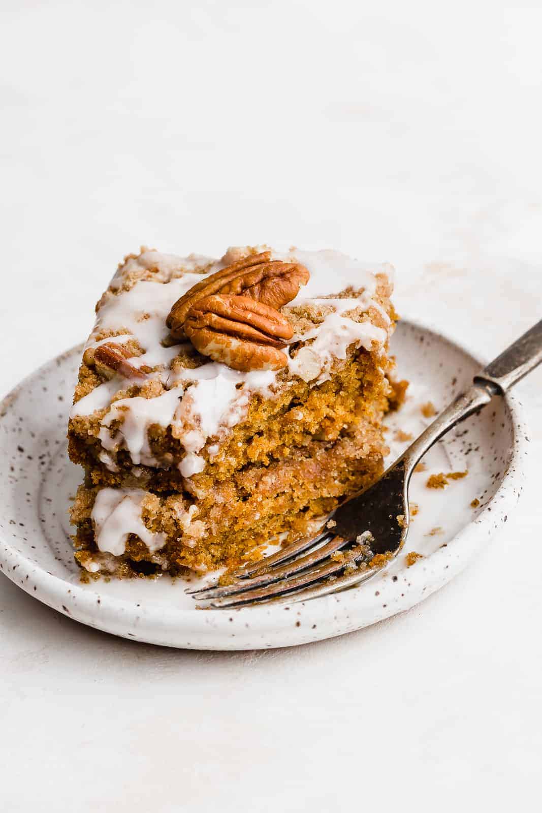Pumpkin Coffee Cake on a white plate with a fork.