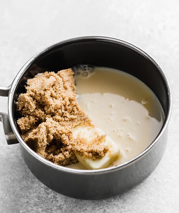 A saucepan with sweetened condensed milk, brown sugar, and butter for making caramel apple dip. 