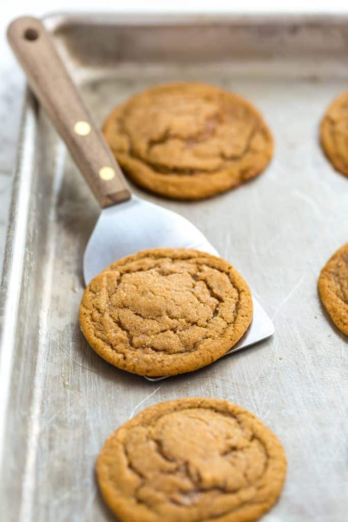Soft gingersnap cookies on a baking sheet.