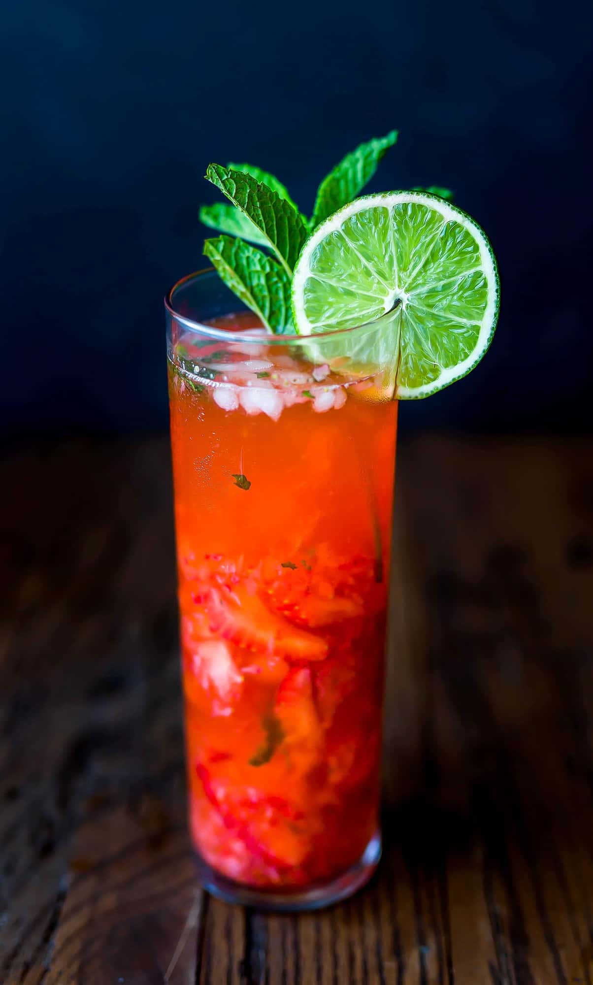 Virgin strawberry lime mojito with a lime wedge on the rim of the glass. 