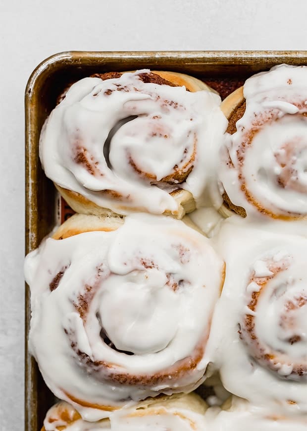 A close up photo of frosted cinnamon rolls.