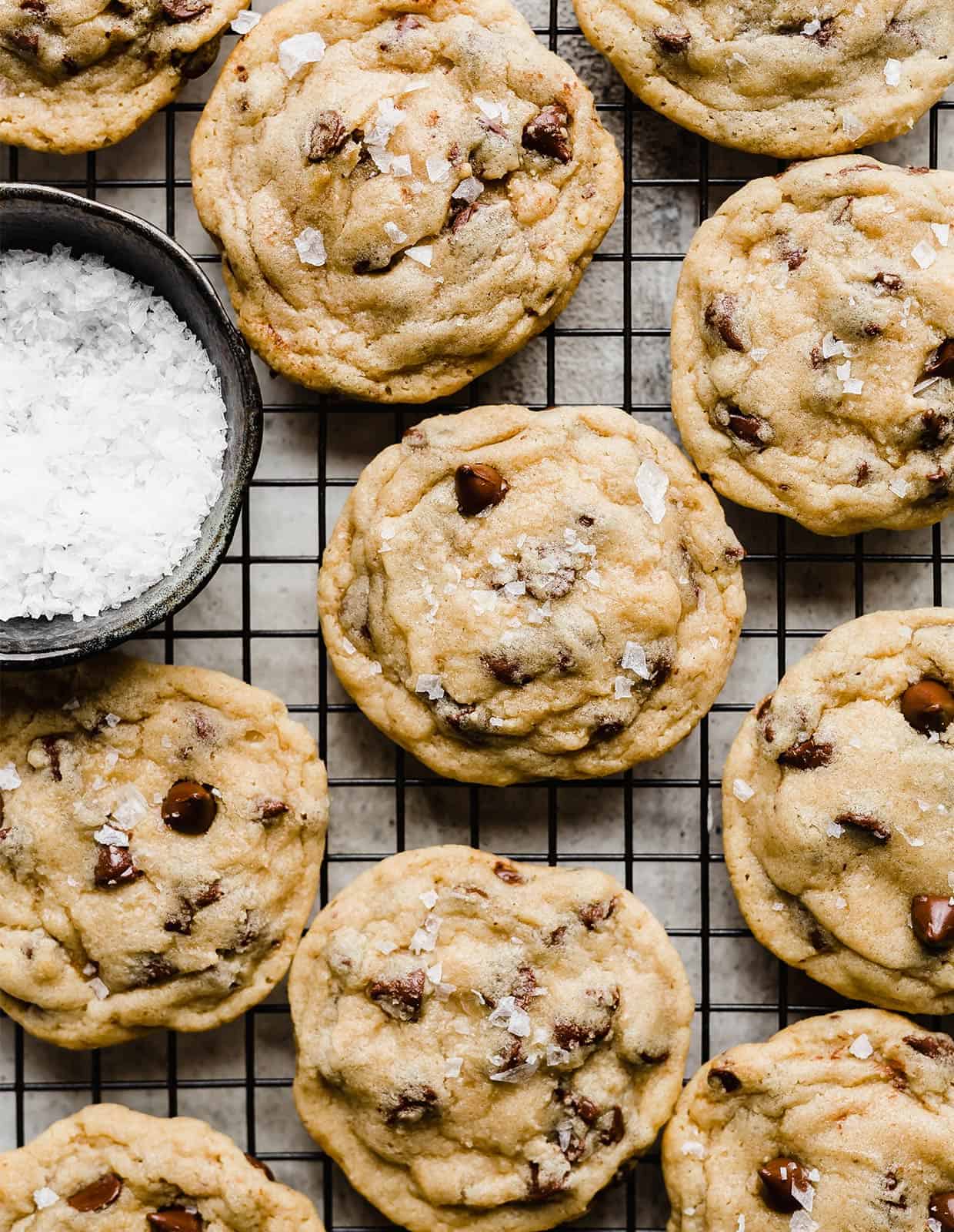 Chocolate chip cookies on a black wire rack.