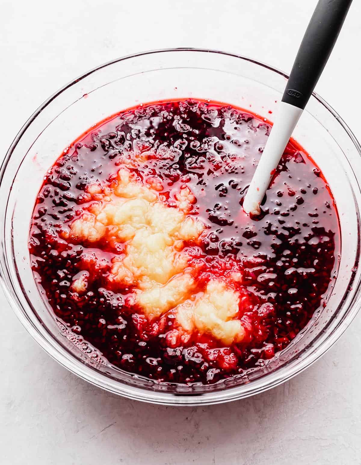 Crushed pineapple in a dark red liquid Pomegranate Jell-O solution.