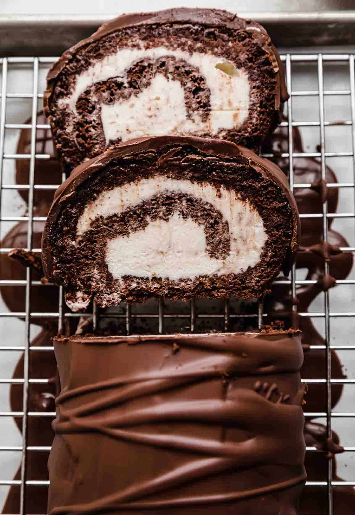 Glaze covered chocolate Ice Cream Cake Roll on a wire rack.