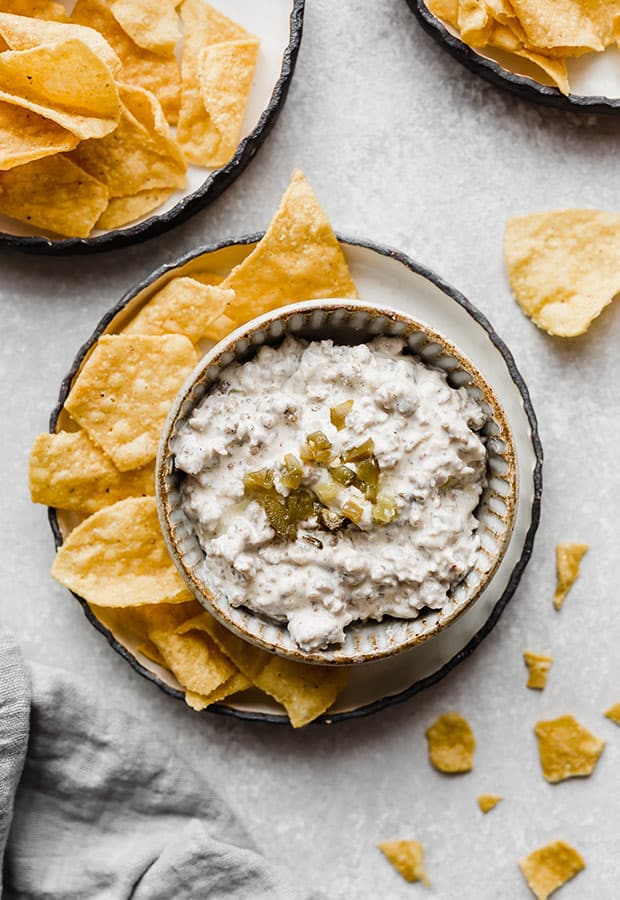 Sausage dip in a bowl with tortilla chips surrounding it.