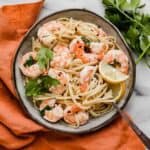 Shrimp Scampi with Linguine in a gray bowl with a garnish of fresh parsley overtop.