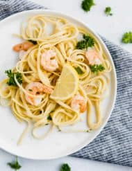 Shrimp Scampi with Linguini and a lemon wedge.