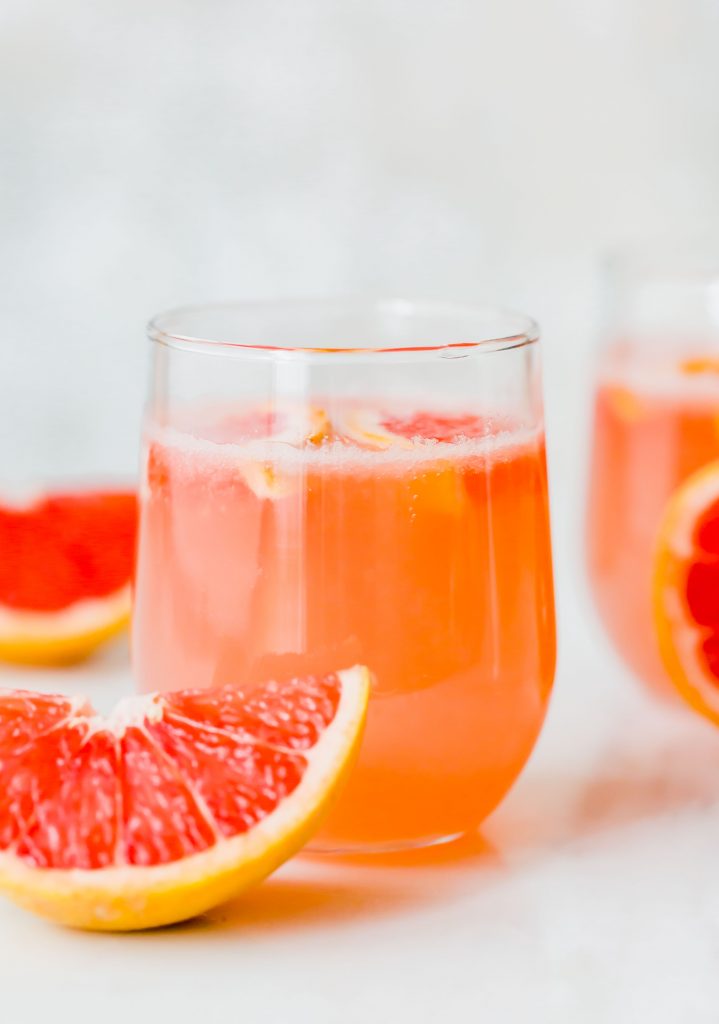 Grapefruit Italian Soda with a grapefruit wedge sitting in front of the glass. 