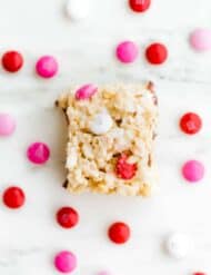 Square Rice Krispie treat made with pink, red, and white M&M's.