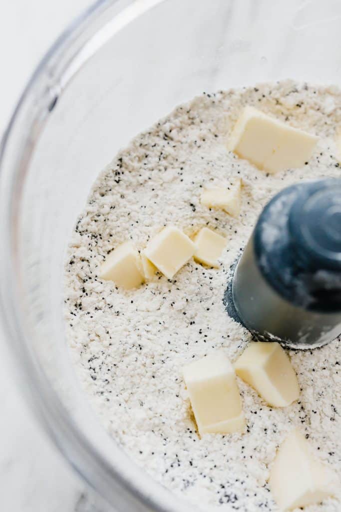 The dry ingredients for the Lemon Poppy Seed Scones in the bowl of a food processor. 