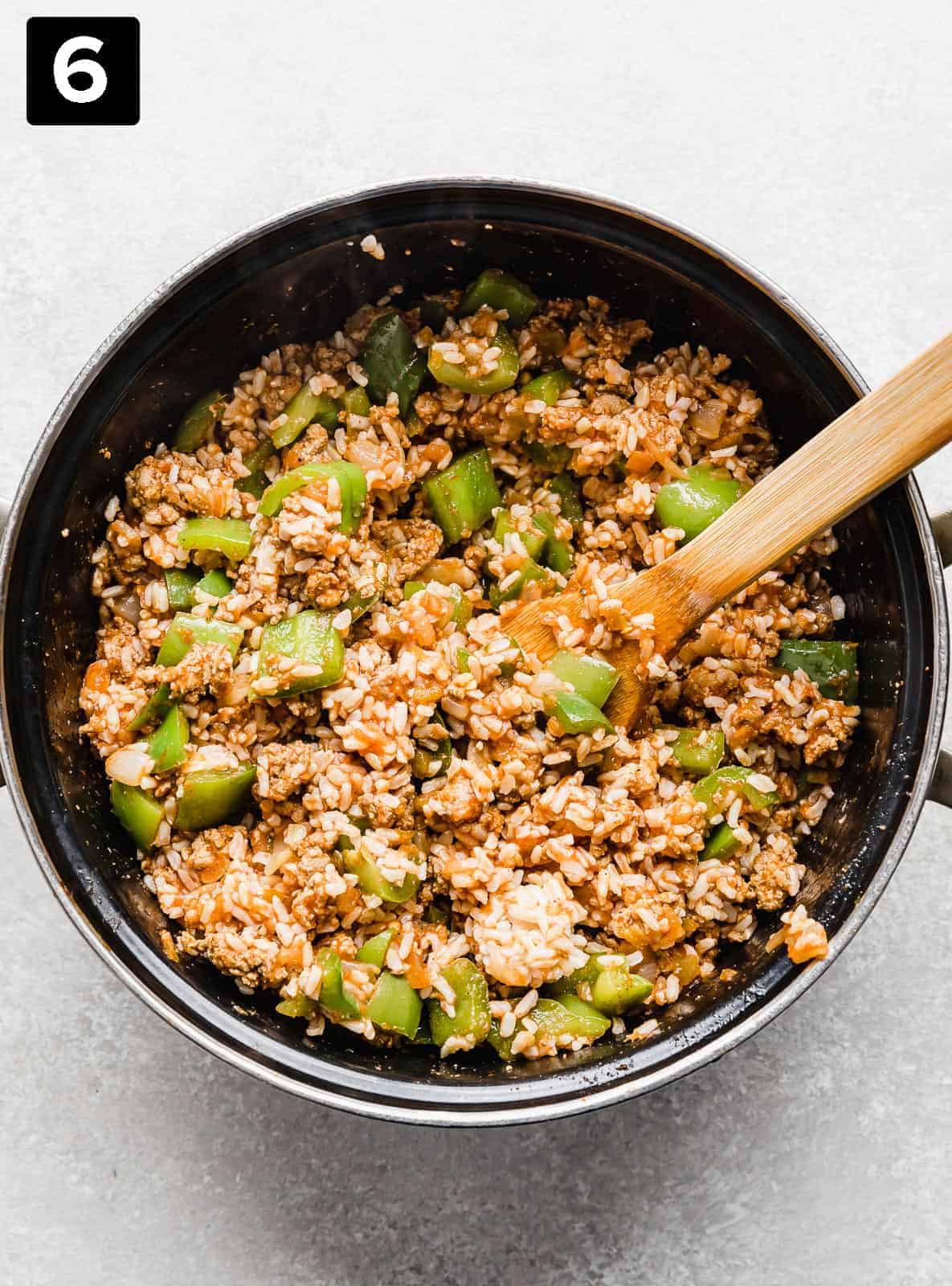 Deconstructed Stuffed Peppers in a large black pot against a light gray background. 