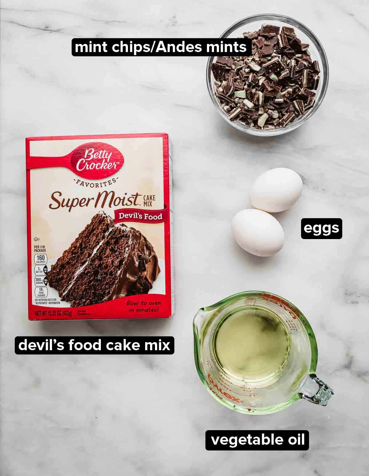 Devil's Food Cake Mix Cookies ingredients on a white background: Andes mints, cake mix, oil, and two eggs.