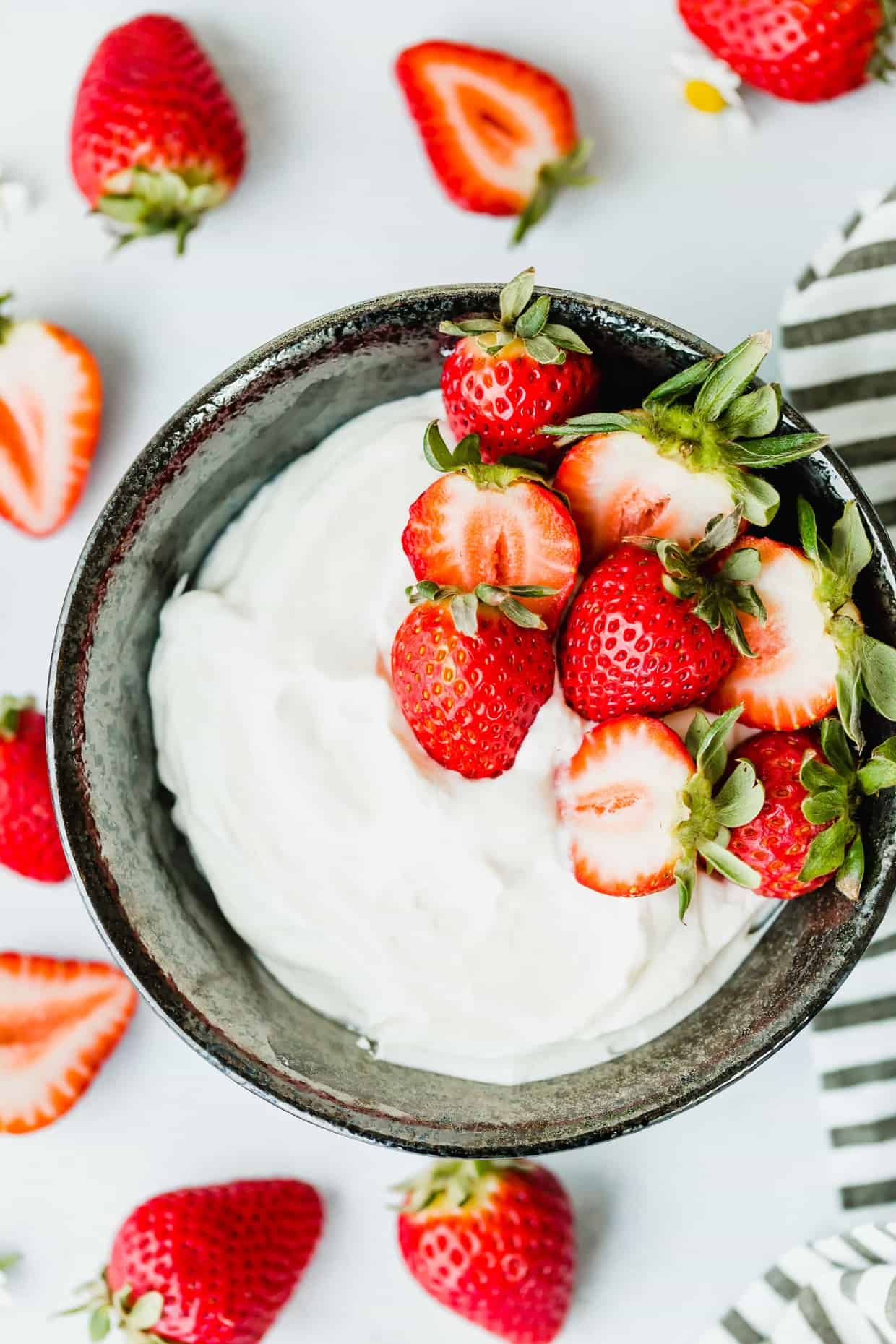 This Greek Yogurt Whipped Cream is beyond refreshing! Add strawberries, peaches, or the fruit of your choice and you have an easy and delicious dessert!
