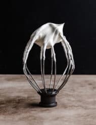 A whisk attachment with Greek Yogurt Whipped Cream on it.