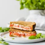 This Grilled Tomato, Mozzarella, and Pesto Sandwich is bursting with flavor! The pesto, mayo, and tomato make for an extra moist and juicy sandwich!