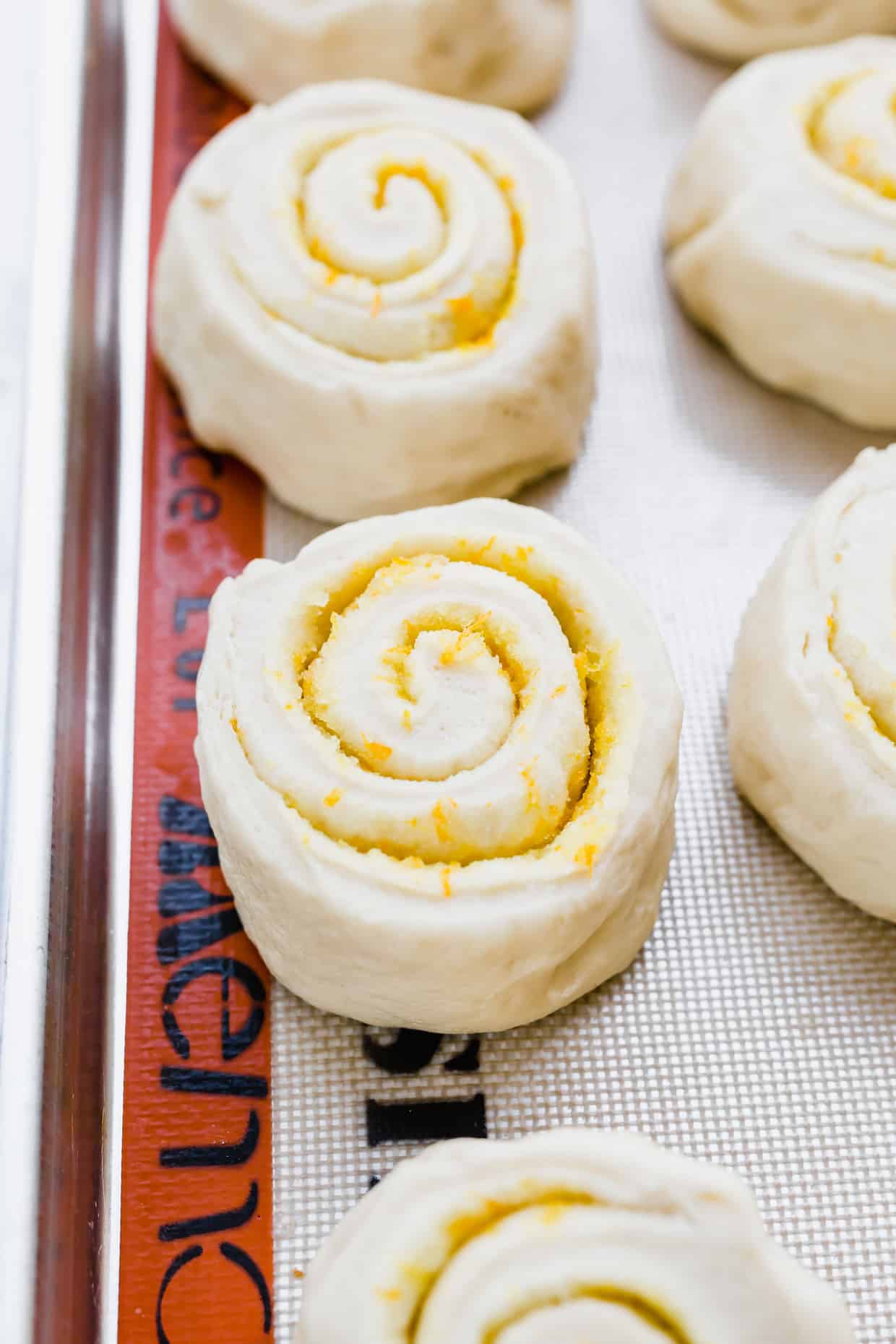 Easy homemade orange sweet rolls rolled into spirals and place on a baking sheet.