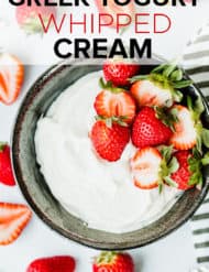 Black bowl with greek yogurt whipped cream and fresh strawberries as garnish.