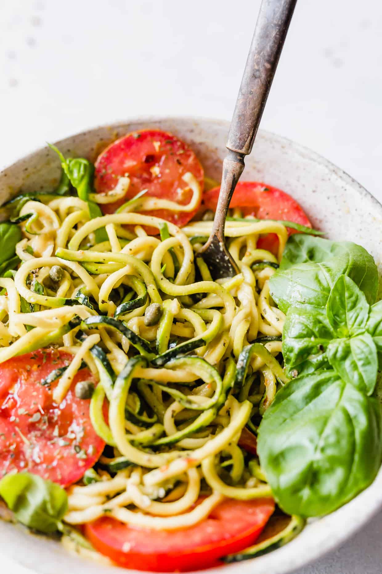 Delicious zucchini noodles are used to make this 5-Minute Cheesy Zucchetti Bowl from Cotter Crunch's new cookbook! This dish takes 5 minutes to make, is gluten-free, and low carb!
