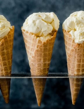 Homemade Creamy Vanilla Ice Cream scooped into three waffle cones.