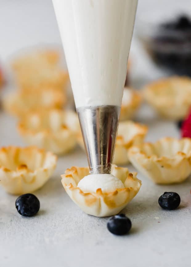 Greek yogurt whipped cream being piped into a Fillo shell