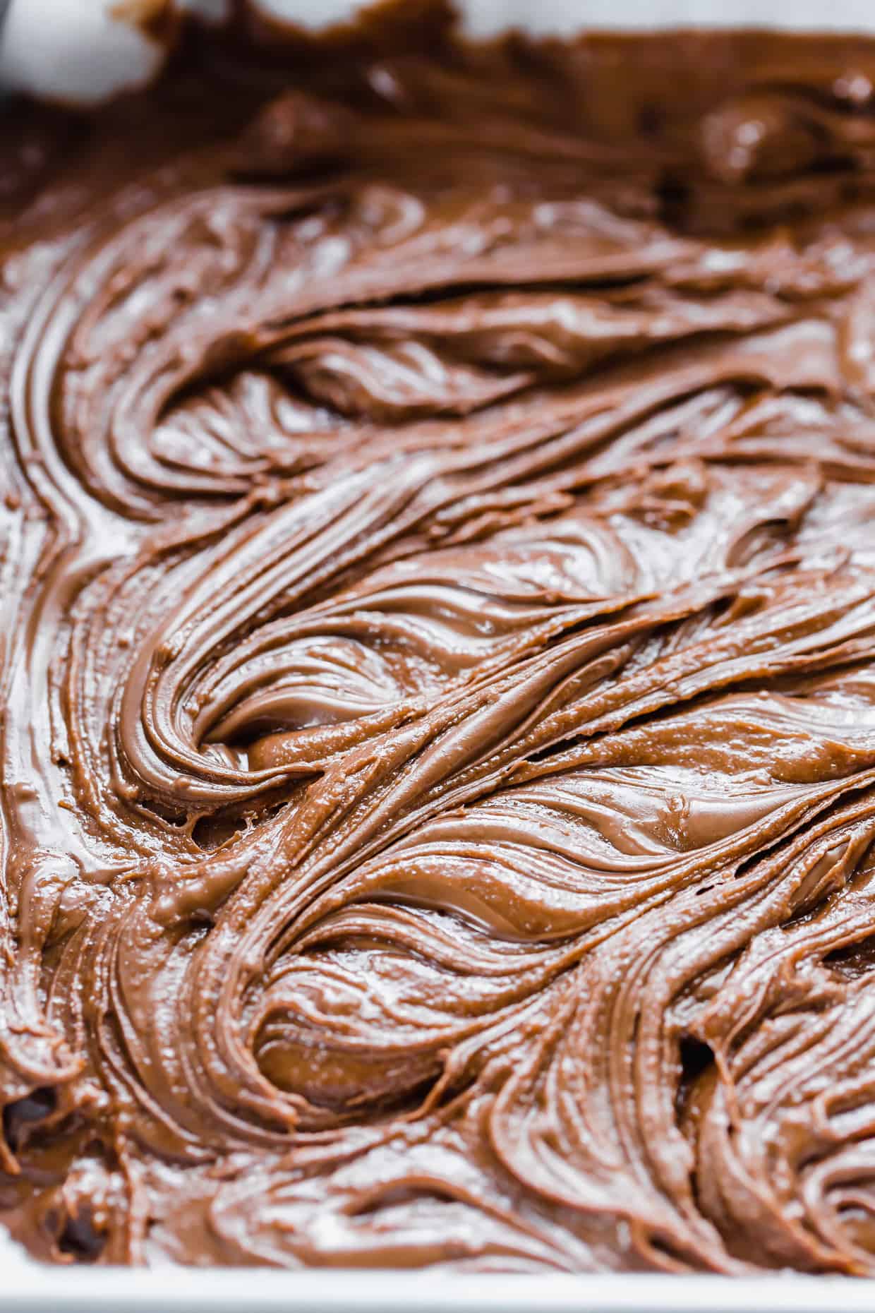 Nutella Brownies batter having dollops of Nutella swirled into the batter. 