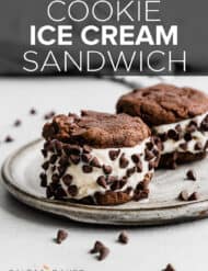 Two Cookie Ice Cream Sandwiches on a gray plate with the vanilla ice cream covered in mini chocolate chips.