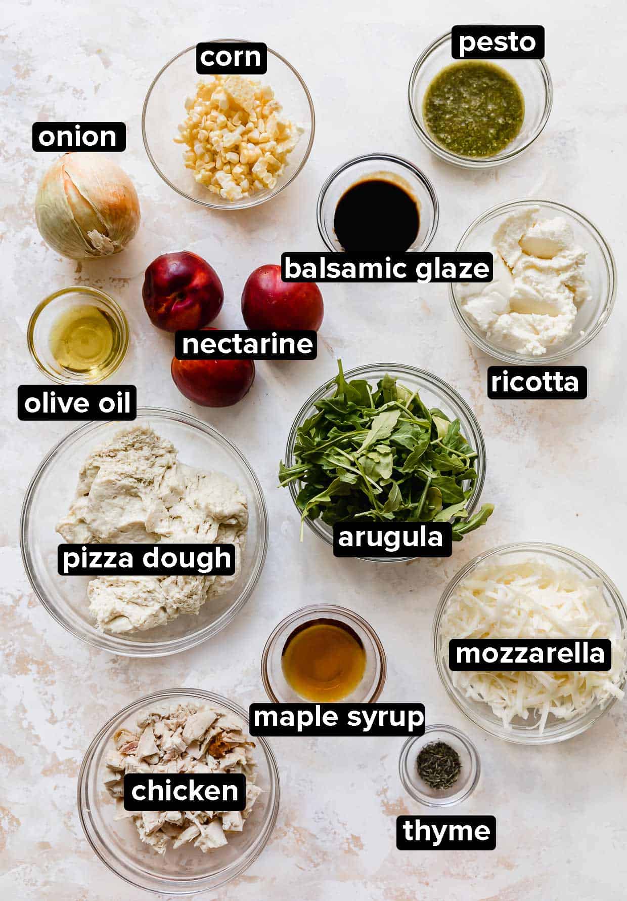 Arugula Pizza ingredients portioned into glass bowls on a white background, ingredients include: ricotta, nectarines, chicken, thyme, corn, onion, pesto.