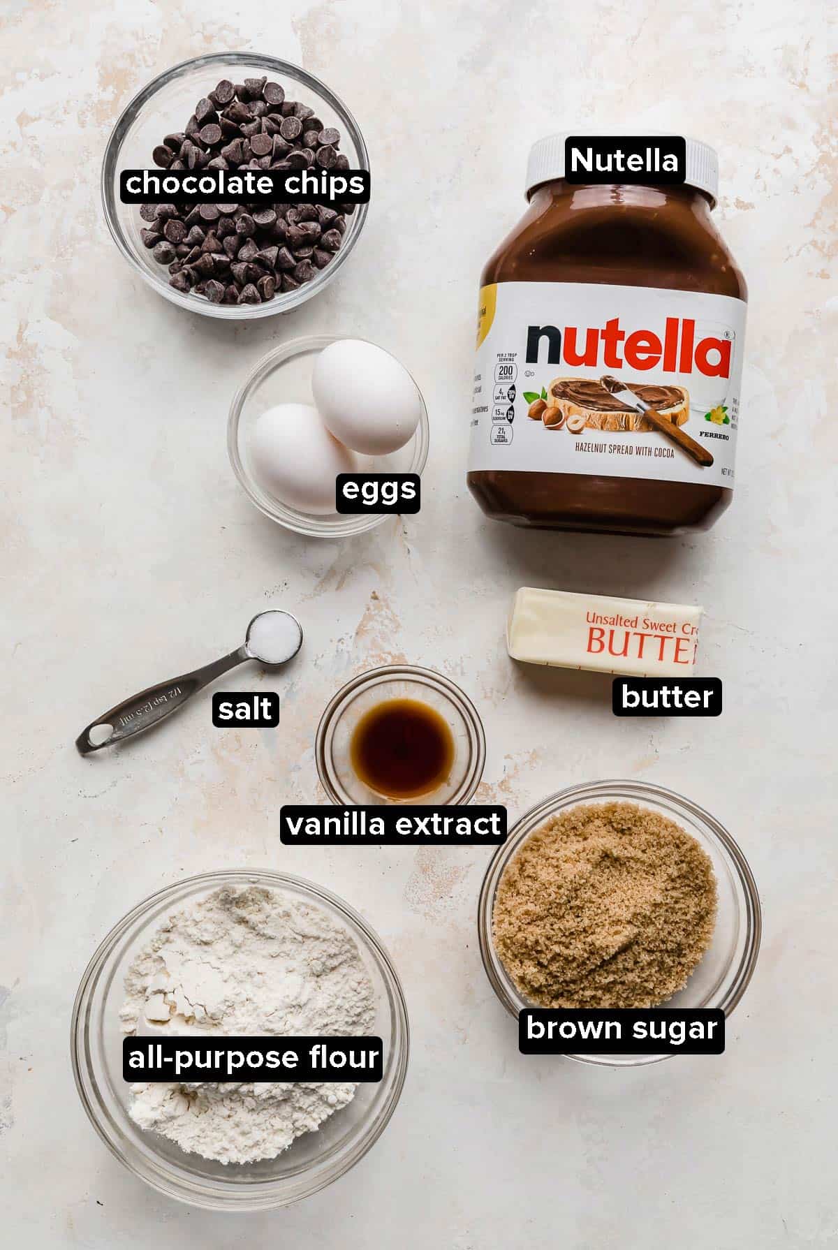 Nutella Brownie ingredients laid out on a white textured background.