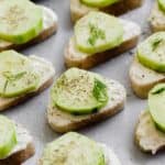 Cucumber Sandwich Appetizer featuring baguette slices topped with cucumber and dill.