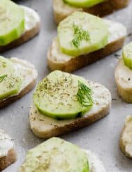 Cucumber Sandwich Appetizer featuring baguette slices topped with cucumber and dill.