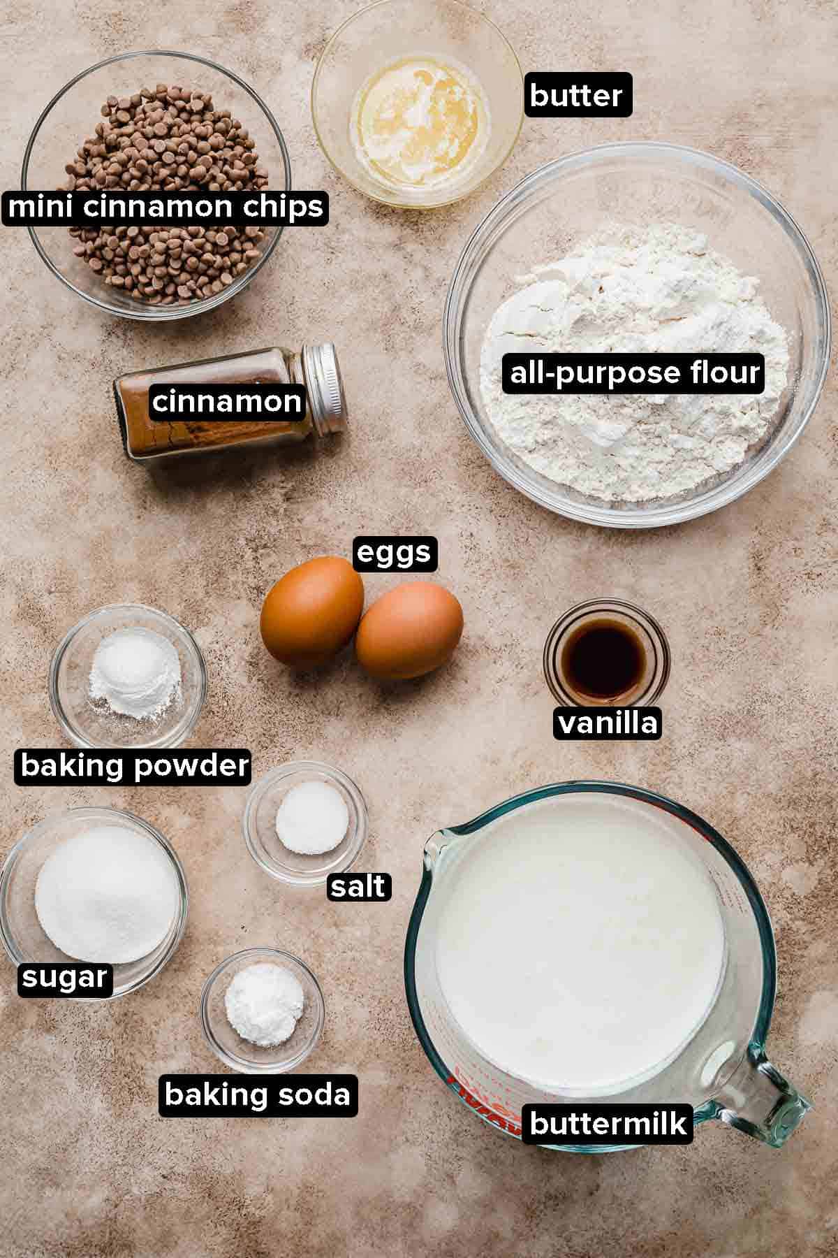 Cinnamon Chip Pancake ingredients portioned into glass bowls on a light brown and beige background.