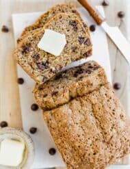 Overhead view of sliced chocolate chip zucchini bread with a square of butter on a slice of bread.