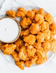 Overhead photo of Buffalo Chicken Bites on a plate and bleu cheese dip in a bowl.