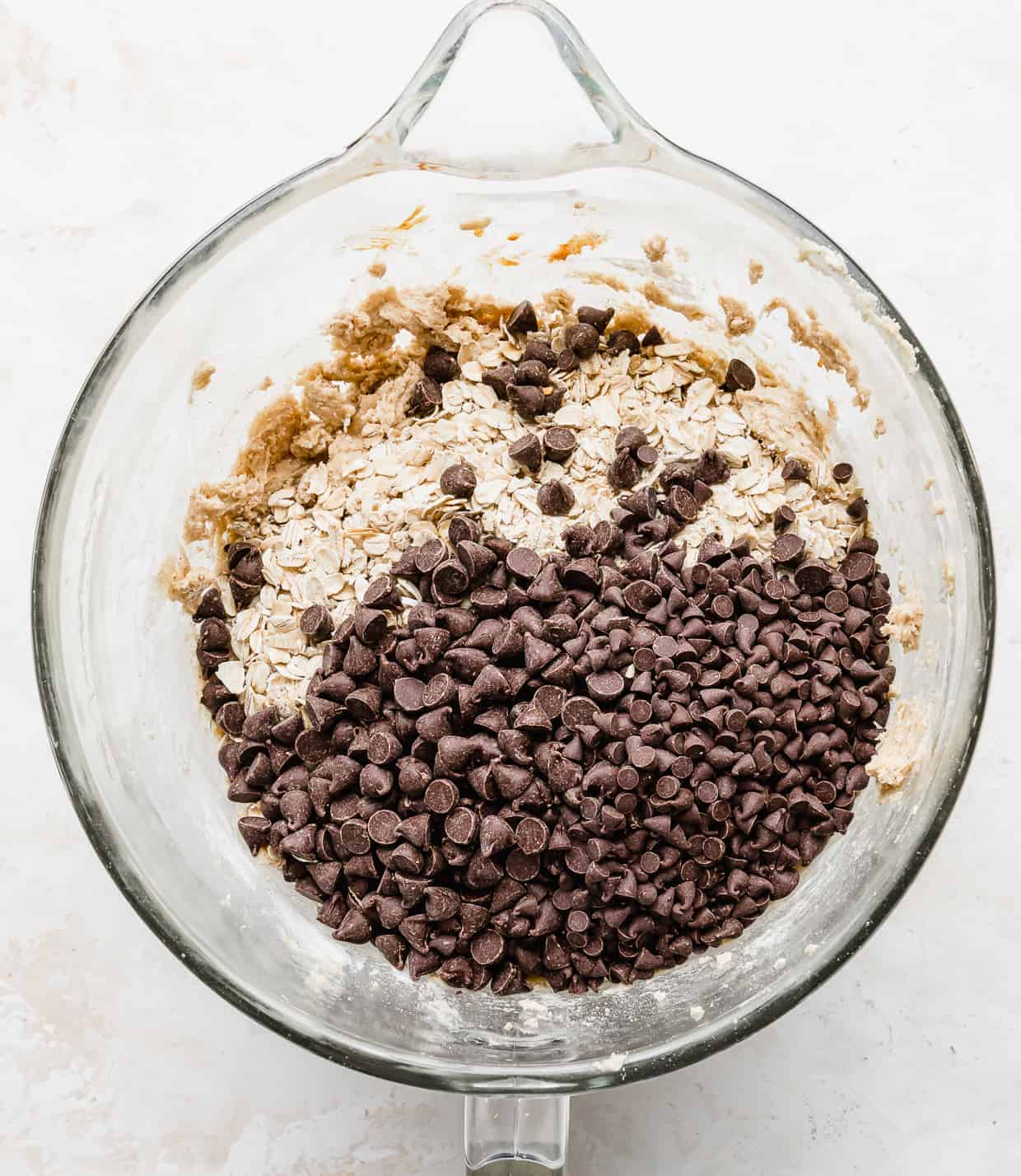 Chocolate chips and rolled oats in a stand mixer bowl.