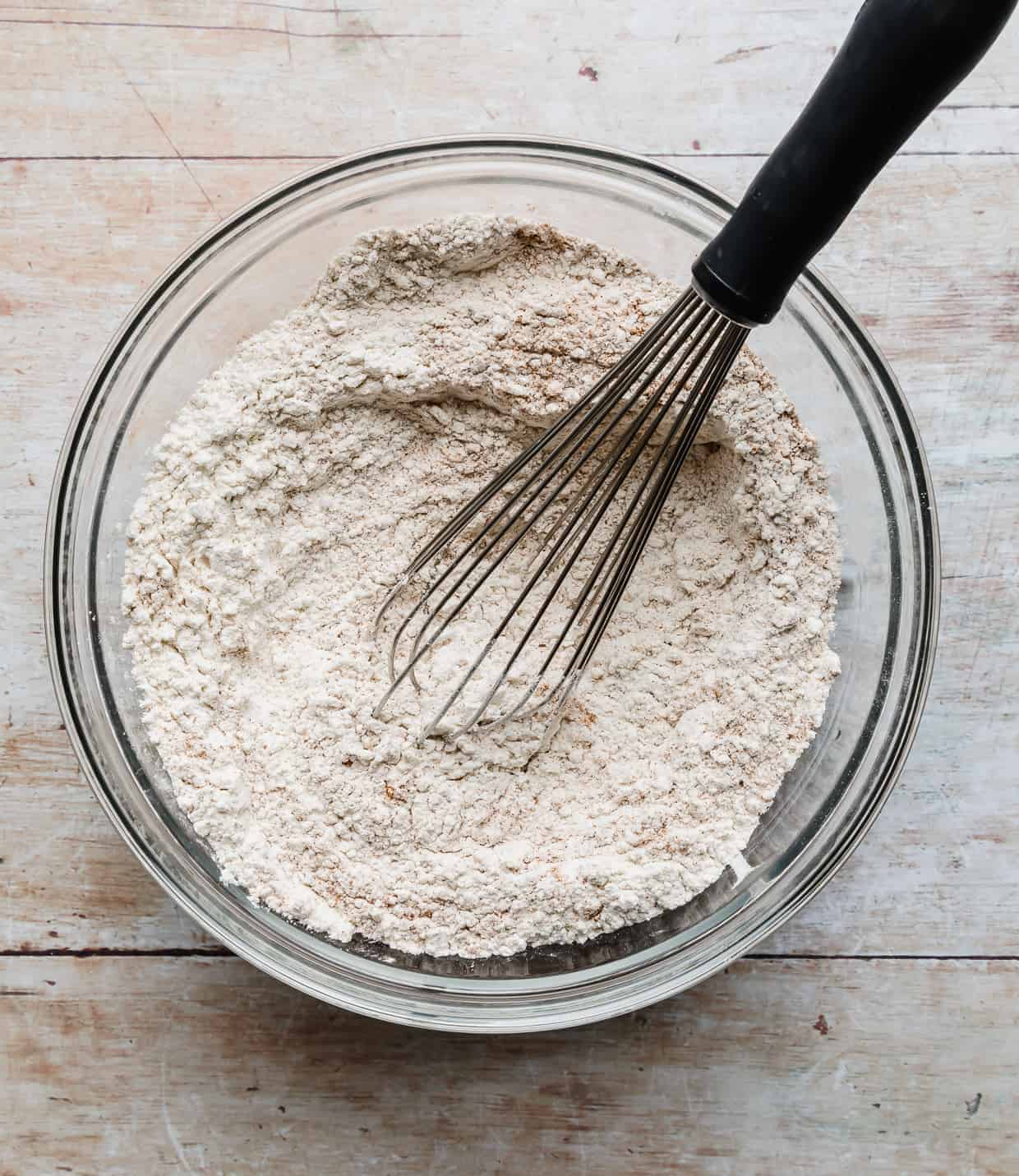 A whisk stirring flour and dry ingredients.