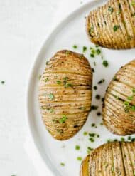 Hasselback Potatoes with a garnish of fresh chives.