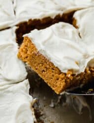Libby's Pumpkin Bars with cream cheese frosting cut into a square, balancing on a metal spatula.