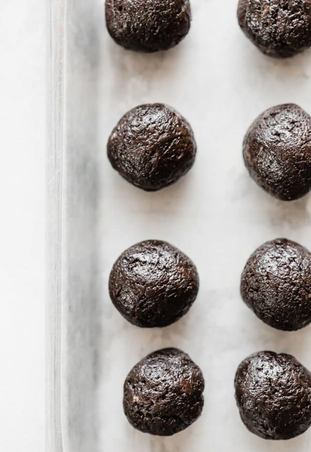 Oreo balls lining a cookie sheet prior to dipping in chocolate.