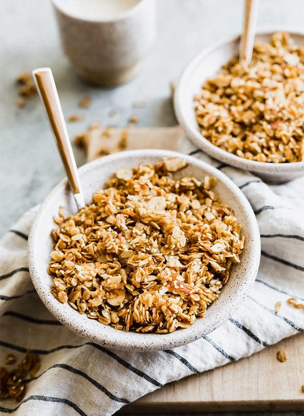 Brown granola in a handmade ceramic bowl. 