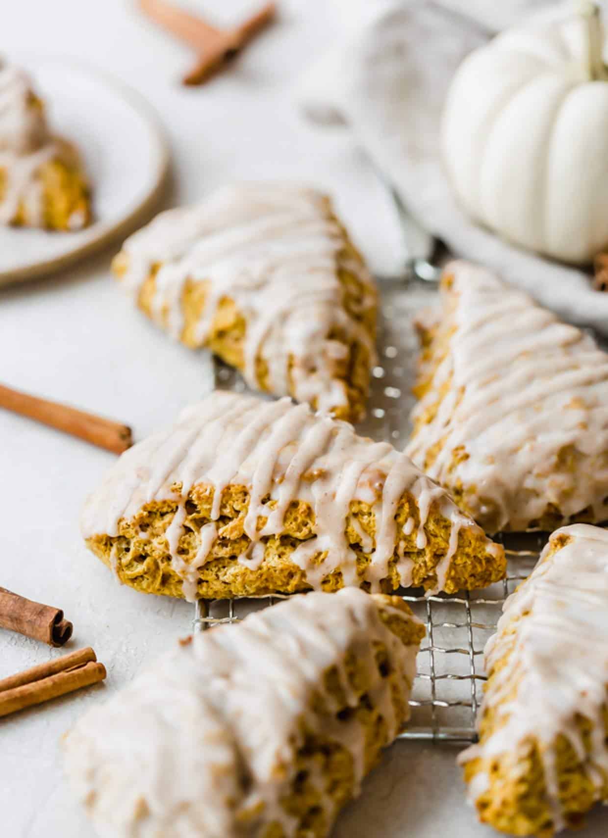 Glazed Pumpkin Scones with spiced glazed on a white background.