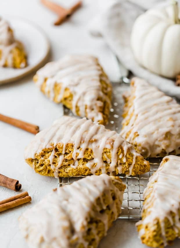 Pumpkin scones with a spiced glaze on a cooking rack.