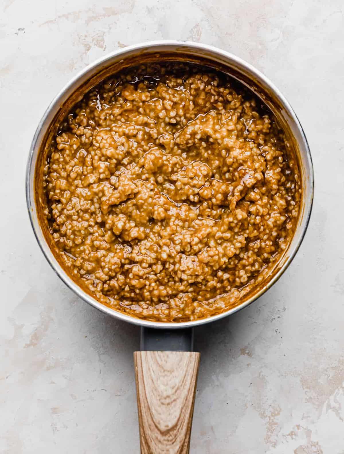 Pumpkin Steel Cut Oats in a white saucepan on a white background.