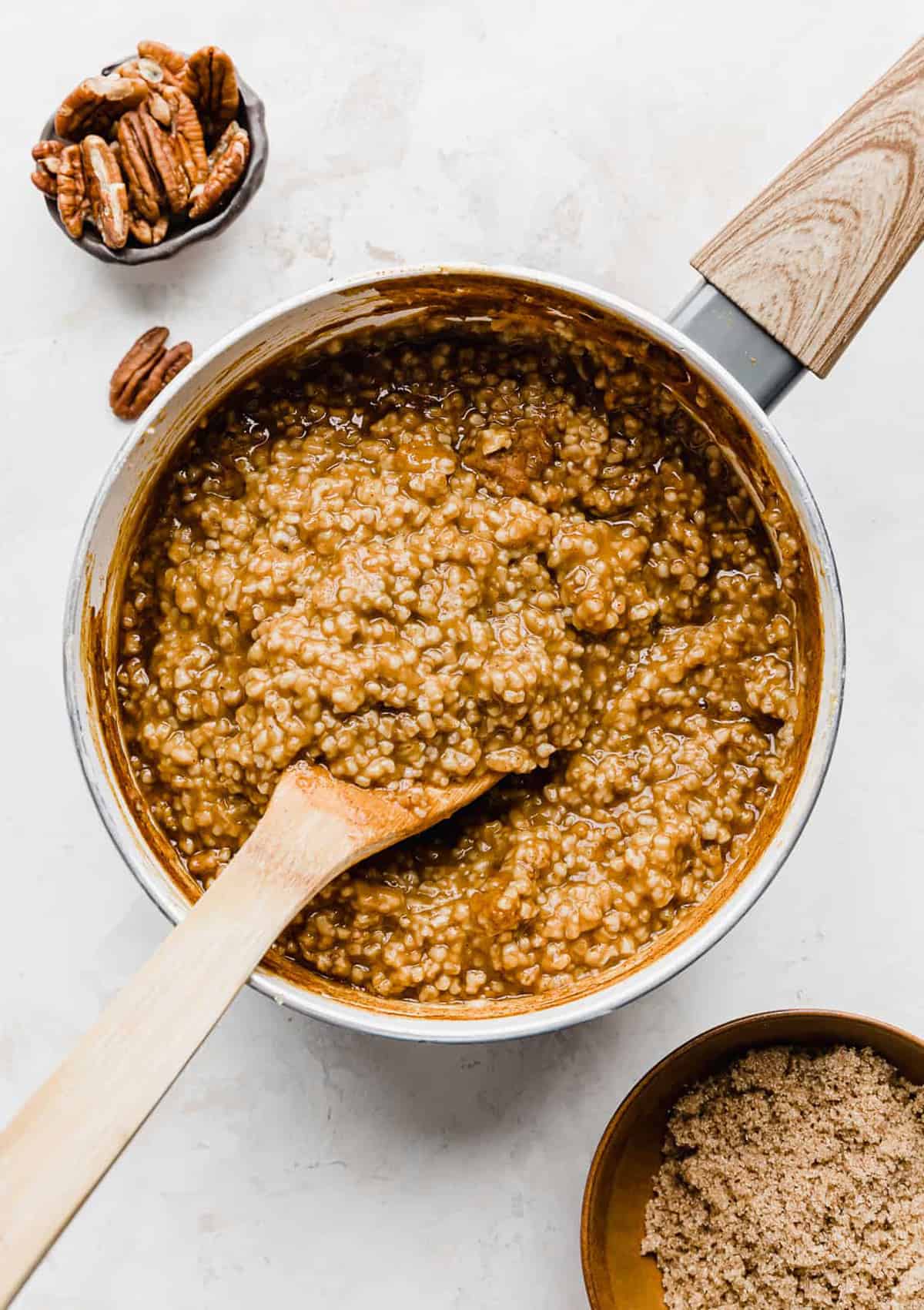 A wooden spoon stirring Pumpkin Steel Cut Oats.